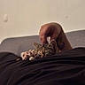 Jetta participe au concours pour gagner de l'argent avec cette photo : kitten, cat, sleeping, paws, hand, tattoo, person, black_shirt, couch, indoor, closeup, relaxation, pet, animal, cozy, rest, feline, blurred_background, warm_light, comfort