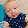 Zander joined the competition — help win amazing prizes! baby, child, infant, portrait, face, blue_eyes, short_hair, smiling, curious, sitting, indoors, cushion, turquoise, navy_clothing, patterned_shirt, sports_balls, arms, hands, wall, close_up