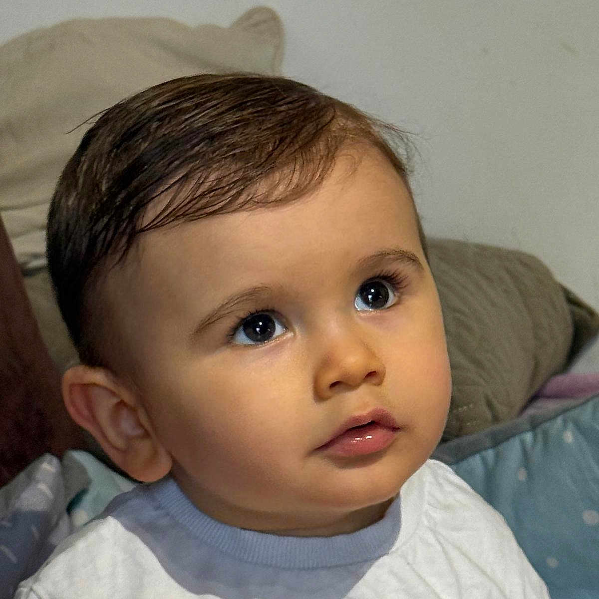 Siméo a rejoint le concours — aidez-le/la à gagner de superbes lots ! baby_clothing, bedding, child, close_up, curious_expression, cute, ear, eyes, face, hair, indoor, infant, lips, long_eyelashes, looking_up, pillow, portrait, shirt, soft_lighting, toddler