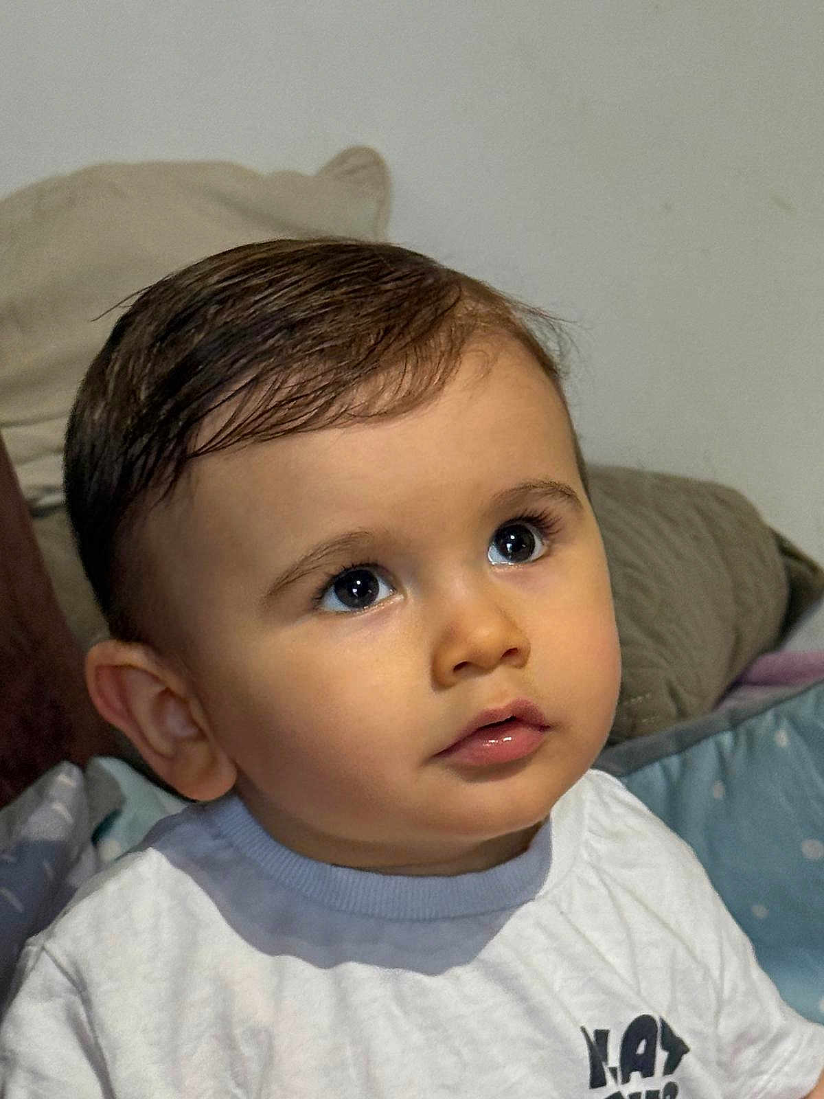 Siméo a rejoint le concours — aidez-le/la à gagner de superbes lots ! child, toddler, infant, face, eyes, long_eyelashes, lips, hair, ear, shirt, pillow, bedding, indoor, portrait, close_up, curious_expression, soft_lighting, cute, baby_clothing, looking_up