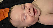 Noah is registered to the contest to win money with this photo: baby, smiling, face, infant, skin, lying_down, happy, child, closeup, head, cheeks, teeth, indoors, portrait, human, cute, expression, baby_skin, baby_face, joy