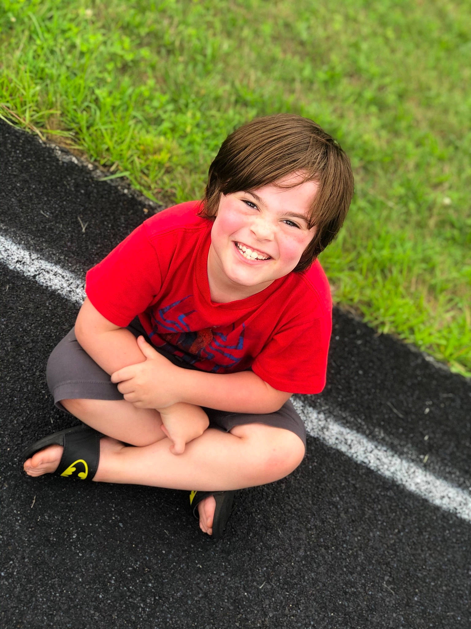 Jose is registered to the contest to win money with this photo: child, facial_expression, fun, grass, happy, joy, leg, leisure, person, photography, play, red, sitting, skin, smile, summer, toddler, vacation