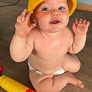 Kayyson is registered to the contest to win money with this photo: baby, child, diaper, helmet, yellow, toy, floor, wooden_floor, sitting, happy, face, hands, cute, indoor, infant, playtime, smiling, chubby, skin, expression