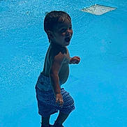Easton is registered to the contest to win money with this photo: child, toddler, water, pool, splashing, swim_trunks, shoes, happy, smiling, summer, outdoor, play, water_surface, shadow, sunlight, bare_chest, wet_hair, fun, recreation, blue