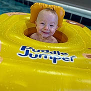Everett is registered to the contest to win money with this photo: baby, child, pool, water, floatie, swimming, yellow, puddle_jumper, infant, smiling, wet_hair, splash, summer, fun, happy, face, head, water_droplets, inflatable, safety