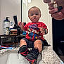 toddler, child, bathroom, sink, countertop, super_mario, red_shirt, black_shoes, sneakers, smartwatch, mirror, hands, rings, toiletries, toothpaste, soap, bottle, person, indoor, casual