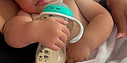 Wes joined the competition — help win amazing prizes! baby, infant, bottle, milk, blanket, soft, cuddle, arm, skin, face, hand, comfort, sleepy, resting, closeup, indoor, child, person, feeding, nurture