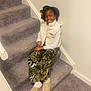 architecture, building, child, clothing, face, female, footwear, girl, hair, happy, head, house, housing, pants, person, photography, shoe, sitting, smile, staircase