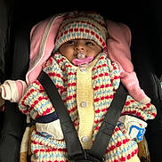 Dhriti a rejoint le concours — aidez-le/la à gagner de superbes lots ! baby, car_seat, pacifier, knit_hat, knit_sweater, colorful_clothing, infant, child, seatbelt, pink_blanket, cute, warm_clothing, baby_mittens, portrait, indoors, cozy, small_child, baby_face, newborn, sitting