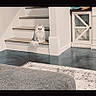 cat, fluffy_cat, white_cat, pet, animal, sitting, staircase, indoors, home, floor, rug, cabinet, furniture, long_hair, fur, portrait, centered_subject, living_area, watchful, photograph