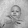 baby, infant, denim_jacket, black_and_white, portrait, face, child, cute, smile, lying_down, soft_texture, clothing, buttoned_jacket, closeup, chubby_cheeks, indoor, young_child, head, skin, expression