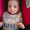 baby, bib, drool, car_seat, child, infant, clothing, person, cute, face, hands, red, black, blue, text, portrait, indoor, young_child, seat, expression