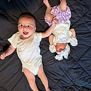 Jeremy joined the competition — help win amazing prizes! baby, infant, child, smiling, sleeping, hand_holding, blanket, headband, mittens, onesie, purple_skirt, quilted_bedspread, cute, adorable, lying_down, indoors, happy, peaceful, two_children, sibling