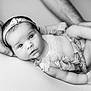 baby, infant, black_and_white, headband, flower, hands, close_up, portrait, newborn, soft_lighting, cute, child, human, skin, peaceful, lying_down, clothing, person, tender, gentle