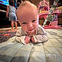 Autumn Rose is registered to the contest to win money with this photo: baby, toddler, child, indoor, playmat, television, toy, quilted_mat, carpet, furniture, living_room, smile, face, crawling, clothing, person, cute, entertainment, home, playtime