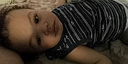 Raphaël participe au concours pour gagner de l'argent avec cette photo : child, face, person, striped_shirt, lying_down, indoor, toddler, portrait, casual_clothing, skin, arm, young, closeup, expression, head, bed, resting, sleepwear, comfort, soft_light