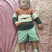 Raphaël a rejoint le concours — aidez-le/la à gagner de superbes lots ! toddler, child, bed, blanket, shirt, fox_design, shorts, socks, lying_down, indoor, pattern, pink, mint_green, curly_hair, casual_clothing, person, young_child, resting, fabric, soft_lighting