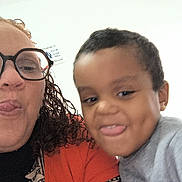 Luka Nathanaël participe au concours pour gagner de l'argent avec cette photo : woman, child, glasses, curly_hair, smiling, tongue_out, indoor, selfie, person, face, apparel, patterned_clothing, short_hair, playful, casual, portrait, happy, light_background, closeup, family