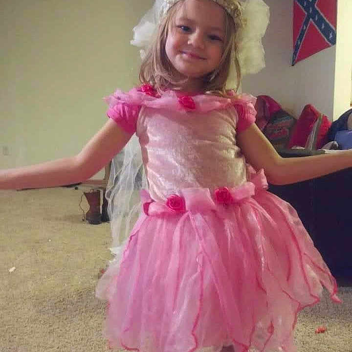 Allison is registered to the contest to win money with this photo: accessories, child, clothing, costume, dress, face, fashion, female, flag, formalwear, girl, head, indoors, jewelry, person, photography, portrait, purple, skirt, toy