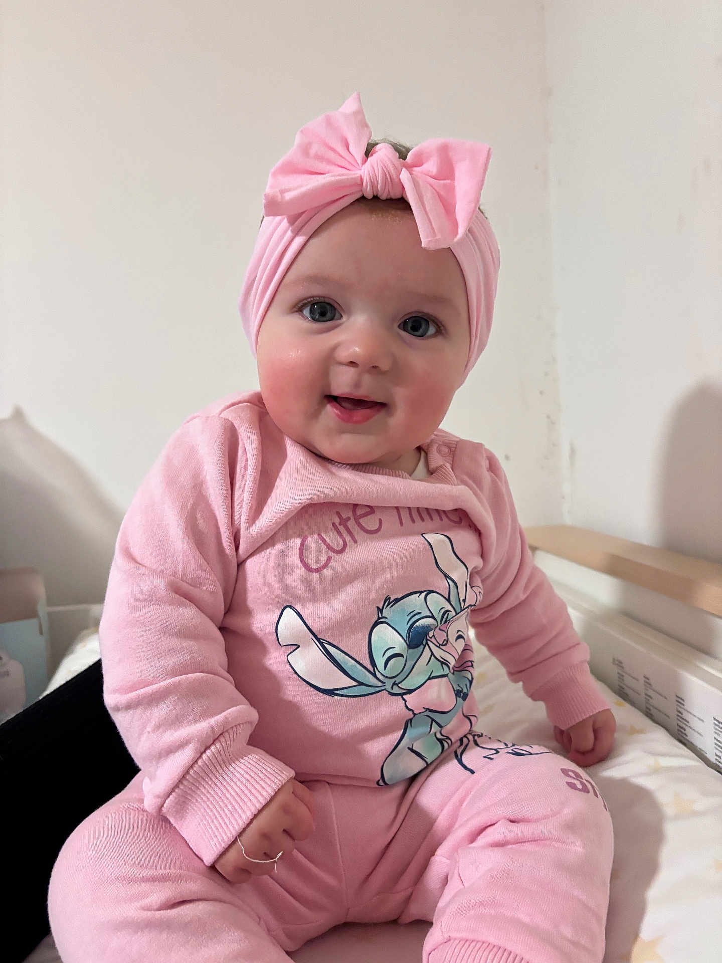 Malyah a rejoint le concours — aidez-le/la à gagner de superbes lots ! baby, child, pink, headband, bow, pajamas, cartoon, smile, face, cute, indoor, sitting, infant, clothing, hands, cheeks, person, portrait, cozy, happy