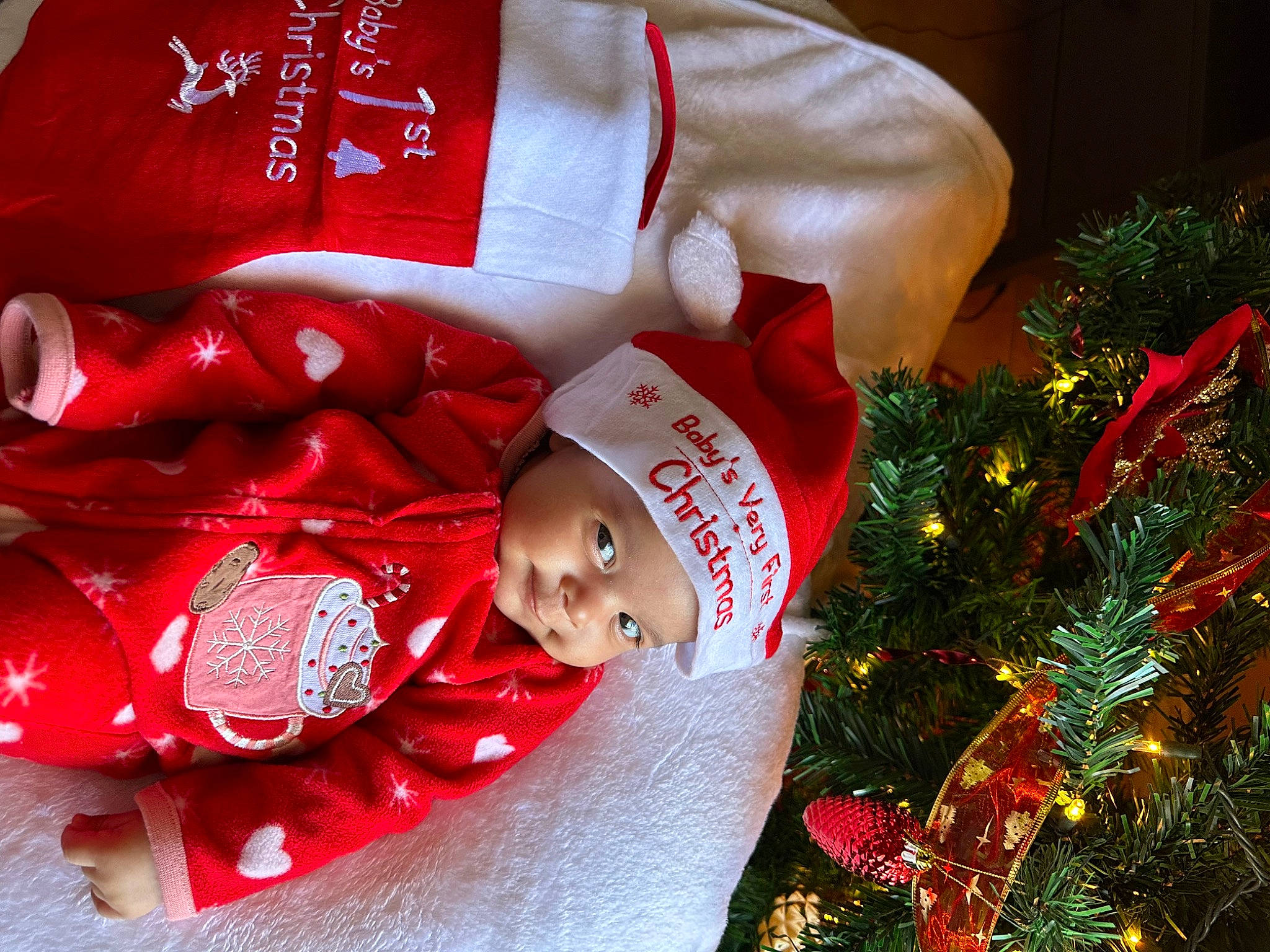 Aubrey joined the competition — help win amazing prizes! baby, carmine, christmas, christmas_decoration, christmas_eve, christmas_ornament, christmas_tree, conifer, event, evergreen, happy, headwear, holiday, holiday_ornament, interior_design, lap, ornament, person, red, smile