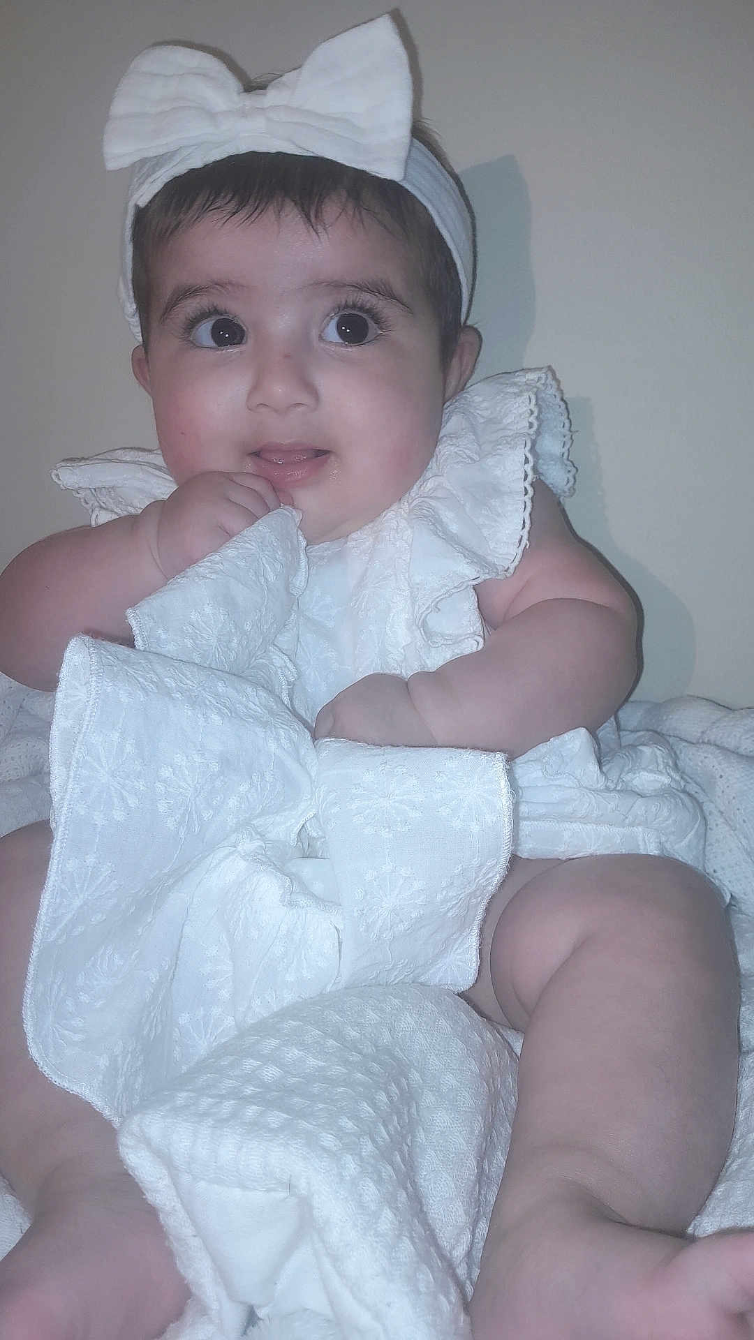 Marwa Khaliq joined the competition — help win amazing prizes! baby, infant, child, white_clothing, headband, bow, blanket, cute, indoors, portrait, closeup, chubby, skin, hand, legs, expression, sitting, fabric, soft_texture, curious