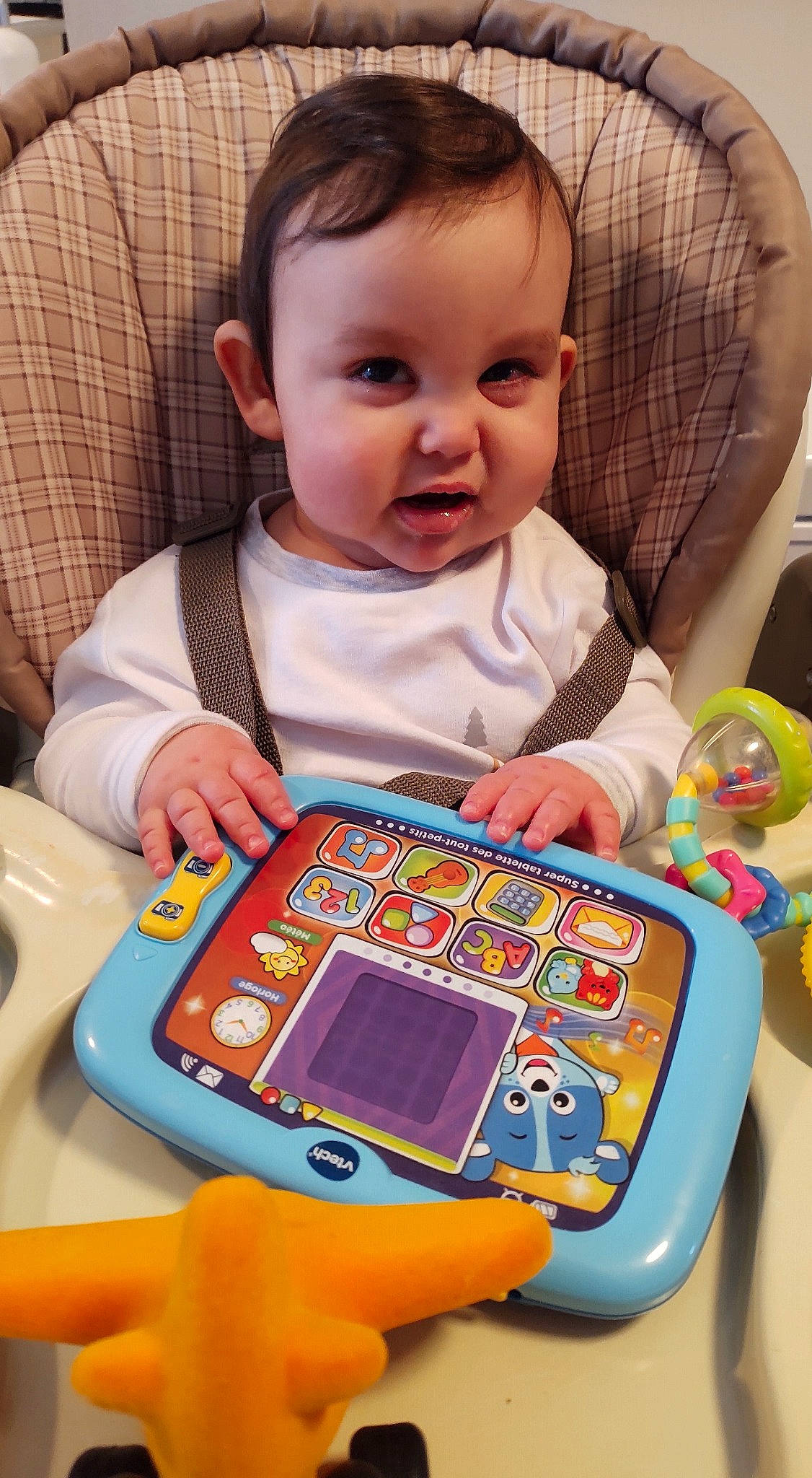 Jacob participe au concours pour gagner de l'argent avec cette photo : baby, baby_playing_with_toys, baby_products, baby_toddler_clothing, blue, chair, cheek, child, electronic_device, fun, gadget, green, indoor_games_and_sports, person, play, portable_electronic_game, room, sharing, sitting, toddler