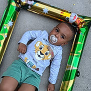 Curtis participe au concours pour gagner de l'argent avec cette photo : baby, barefoot, cartoon_animals, casual_clothing, child, concrete_floor, cute, expression, face, inflatable_frame, jungle_theme, lying_down, outdoor, pacifier, person, shorts, simba, sweatshirt, toddler, young_child