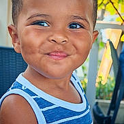 Curtis participe au concours pour gagner de l'argent avec cette photo : background_blur, blue_striped_tank_top, casual_clothing, chair, cheeks, child, cute, daylight, eyes, face, greenery, happy, outdoor, person, portrait, short_hair, shoulder, skin, smiling, toddler