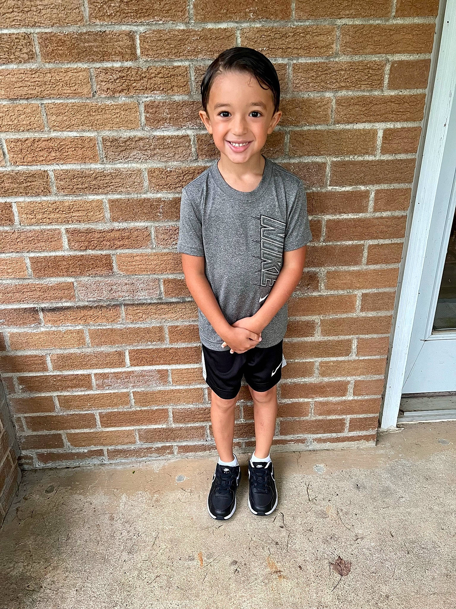 Tavian is registered to the contest to win money with this photo: baby_toddler_clothing, brick, brickwork, clothing, denim, electric_blue, flash_photography, footwear, happy, human_leg, joy, knee, pattern, person, sitting, sleeve, smile, standing, t_shirt, thigh