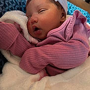 Amaïa is registered to the contest to win money with this photo: baby, sleeping, blanket, headband, pink_clothing, newborn, face, cozy, indoors, soft_texture, cute, infant, resting, portrait, warm, child, peaceful, wrapped, fuzzy, closeup