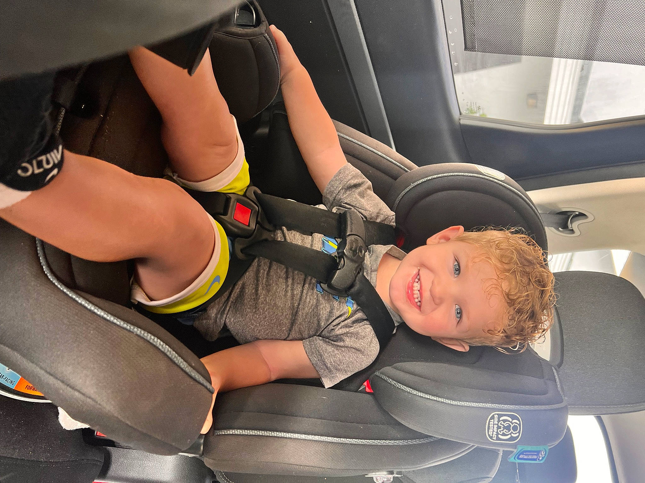 Grayson is registered to the contest to win money with this photo: arm, auto_part, automotive_design, automotive_exterior, automotive_tire, automotive_wheel_system, car, car_seat, car_seat_cover, human_leg, joy, knee, leg, mode_of_transport, motor_vehicle, muscle, person, thigh, tire, vehicle