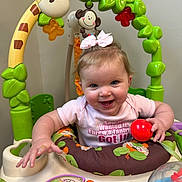 Preszley joined the competition — help win amazing prizes! baby, child, pink_bow, activity_center, giraffe_toy, monkey_toy, red_ball, smiling, happy, infant, playtime, colorful, toddler, indoor, cute, clothing, toy, face, person, entertainment