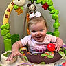 activity_center, baby, child, clothing, colorful, cute, entertainment, face, giraffe_toy, happy, indoor, infant, monkey_toy, person, pink_bow, playtime, red_ball, smiling, toddler, toy