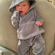 Immanuel joined the competition — help win amazing prizes! baby, infant, newborn, hooded_sweater, knit_pillow, blanket, socks, hand, face, eyes, mouth, cozy, indoor, portrait, clothing, soft_texture, resting, pose, cute, person