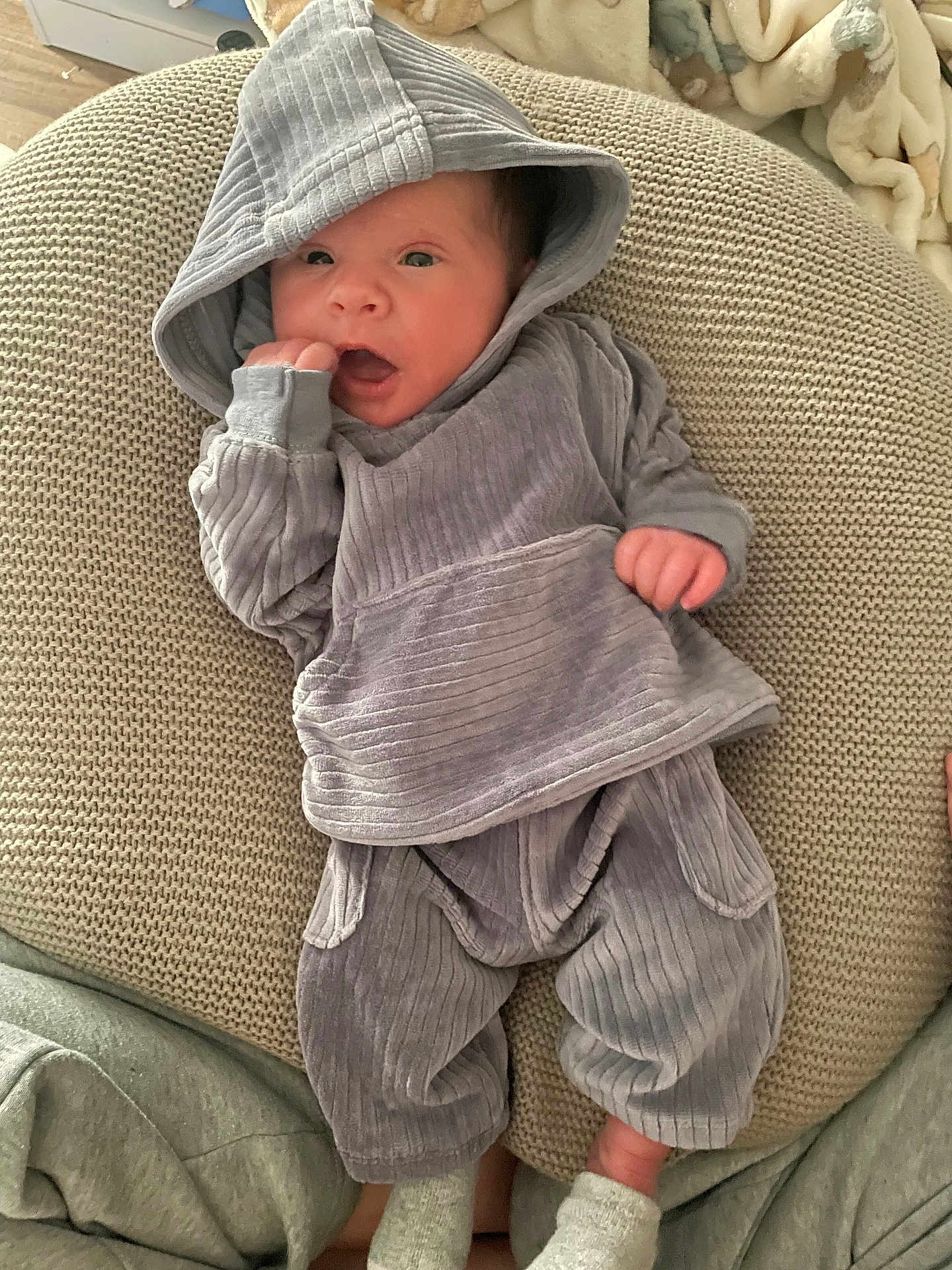 Immanuel joined the competition — help win amazing prizes! baby, infant, newborn, hooded_sweater, knit_pillow, blanket, socks, hand, face, eyes, mouth, cozy, indoor, portrait, clothing, soft_texture, resting, pose, cute, person