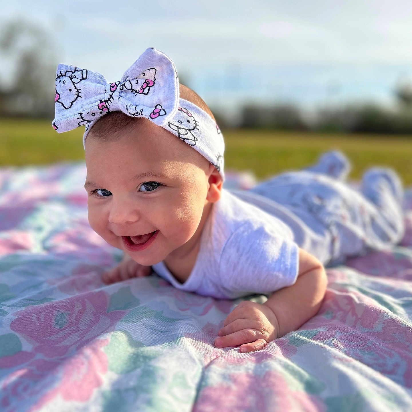 Elaina is registered to the contest to win money with this photo: accessories, baby, babylaughing, blanket, clothing, crawling, dress, face, grass, happy, hat, head, headband, newborn, person, photography, plant, portrait, quilt, smile