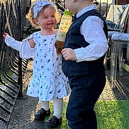 Layla-Marie joined the competition — help win amazing prizes! child, toddler, baby_bottle, dress, suit, headband, outdoor, balcony, sunset, smile, curly_hair, short_hair, footwear, railing, grass, brick_wall, plastic_chair, cute, playing, interaction