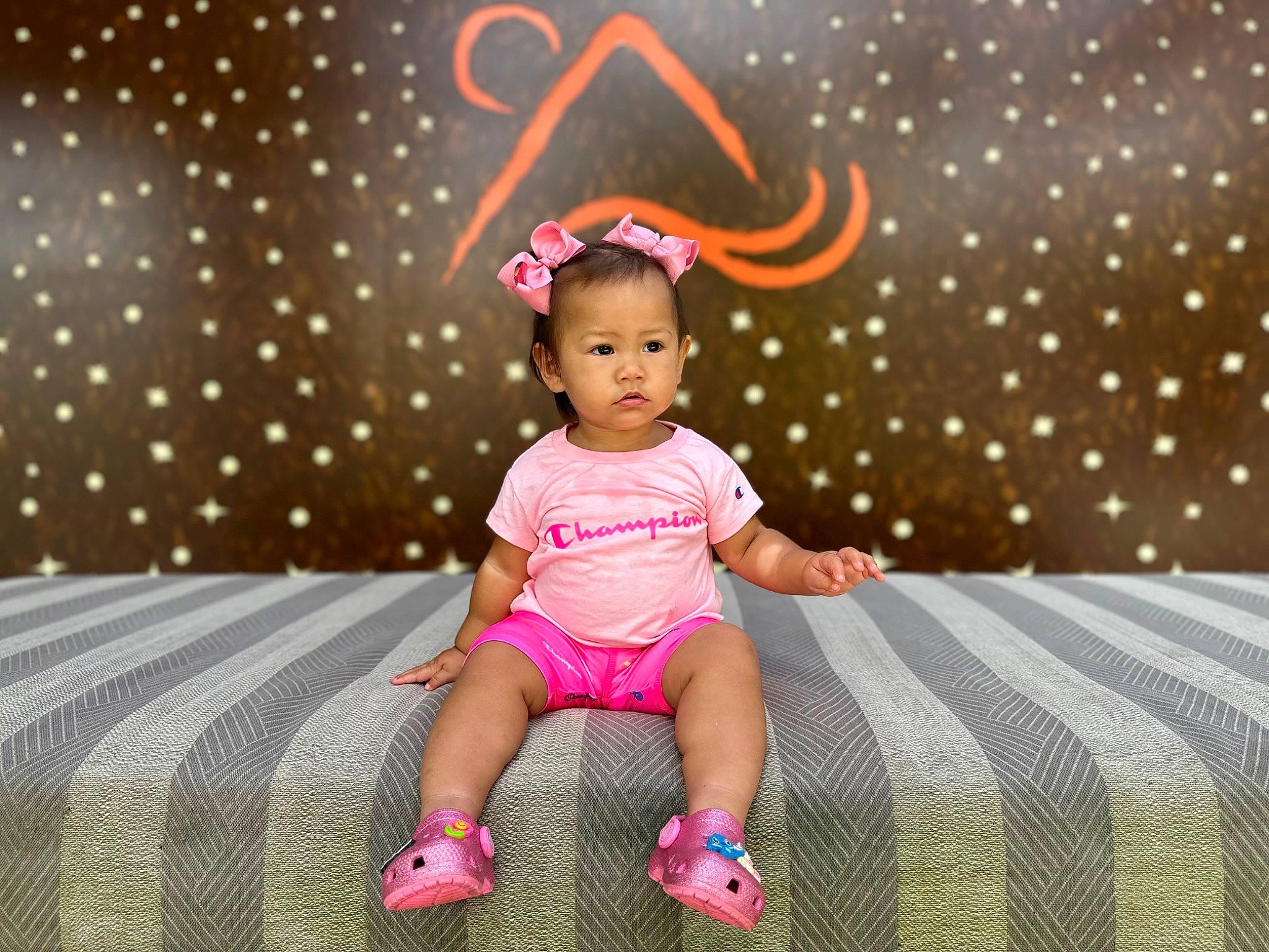 Kailia is registered to the contest to win money with this photo: baby_toddler_clothing, child, comfort, event, flooring, fun, happy, human_leg, leg, leisure, lighting, linens, magenta, pattern, person, pink, room, sandal, sitting, toddler
