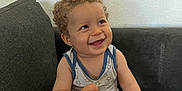 Leeroy a rejoint le concours — aidez-le/la à gagner de superbes lots ! toddler, child, smile, curly_hair, onesie, sitting, couch, indoor, happy, face, skin, baby, furniture, arm, leg, wall, pattern, star, expression, person