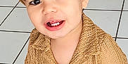 Aslan Castano joined the competition — help win amazing prizes! toddler, child, hat, straw_hat, smile, indoor, tile_floor, watch, smartwatch, shirt, beige, cute, person, happy, baby, arm, toy, furniture, living_room, casual