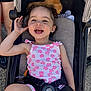 toddler, child, stroller, smiling, curly_hair, outdoor, sunny, plush_toy, pink_flower_outfit, happy, person, seatbelt, casual_clothing, legs, footwear, daylight, playful, cute, baby, portrait