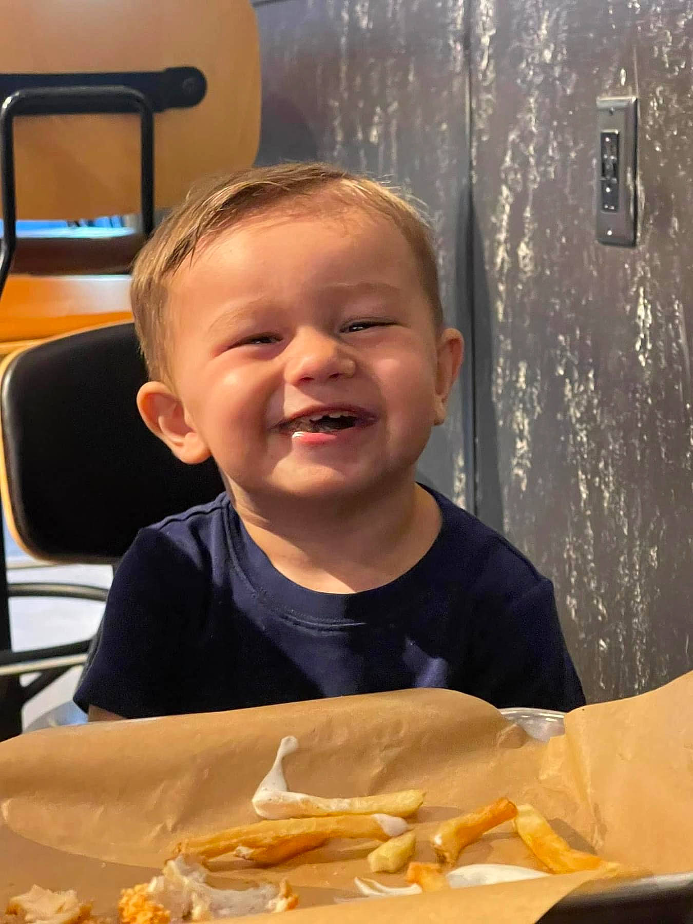 Cody is registered to the contest to win money with this photo: chair, cheek, child, chin, comfort_food, cuisine, dish, fast_food, finger_food, food, food_craving, fun, happy, joy, junk_food, organ, people, person, smile, t_shirt