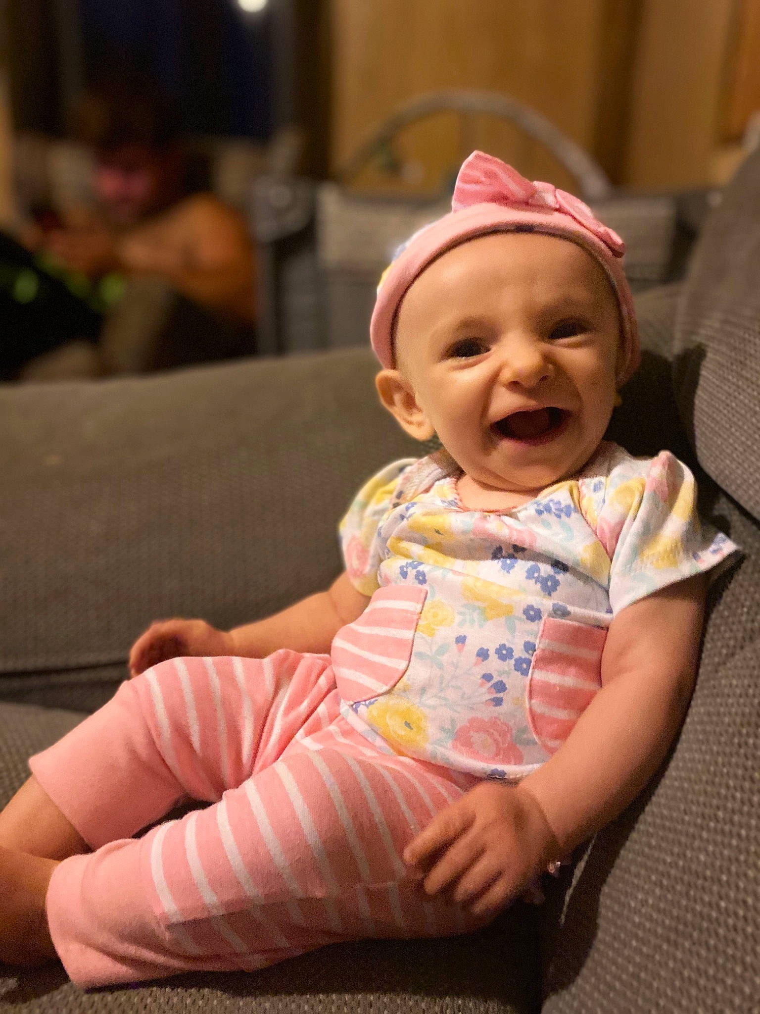 Gracelyn is registered to the contest to win money with this photo: baby, baby_laughing, baby_toddler_clothing, barefoot, bonnet, cheek, child, comfort, couch, finger, foot, lap, living_room, mouth, nose, person, pink, skin, sock, toddler