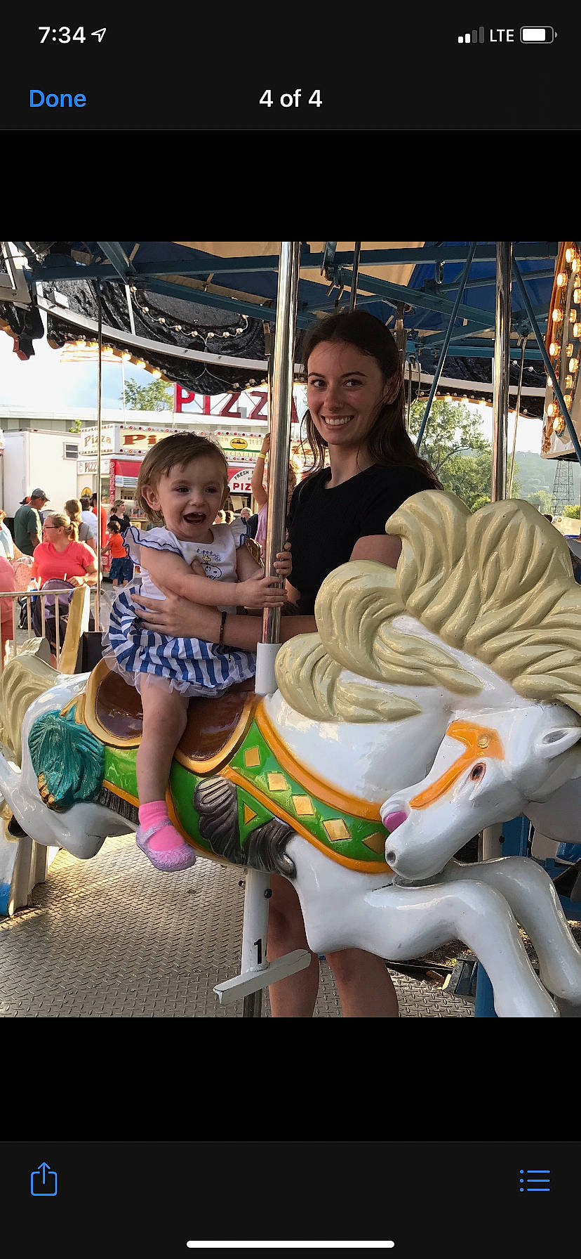 Gracelyn is registered to the contest to win money with this photo: amusement_park, amusement_ride, carousel, event, fair, festival, fun, happy, horse, joy, leisure, nonbuilding_structure, outdoor_recreation, person, playground, public_event, recreation, shorts, smile, temple