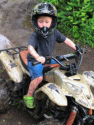 Aiden joined the competition — help win amazing prizes! all_terrain_vehicle, automotive_tire, enduro, headwear, motocross, motorsport, mud, off_road_vehicle, off_roading, person, recreation, soil, trail, vehicle