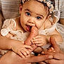 baby, infant, child, portrait, headband, flower_crown, hands, feet, adult_hands, holding, eating, teething, dress, bow, cute, big_eyes, close_up, studio_lighting, family, skin