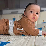 Giulian a rejoint le concours — aidez-le/la à gagner de superbes lots ! baby, brown_clothing, child, closeup, cozy, curious, cute, expression, eyes, face, hand, indoor, infant, lying_down, mattress, pattern, portrait, skin, soft_lighting, young_child