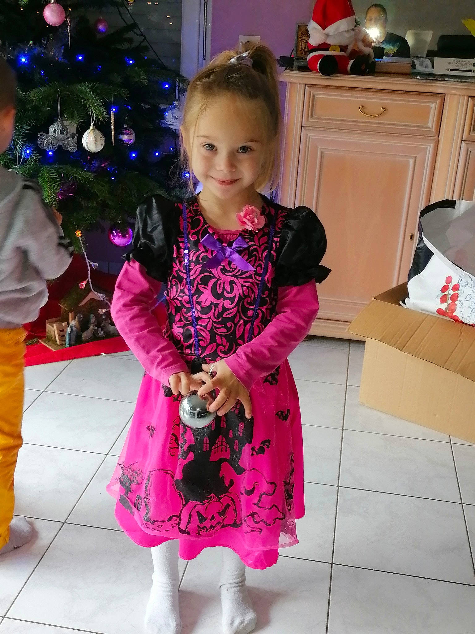 Sarah a rejoint le concours — aidez-le/la à gagner de superbes lots ! arm, baby_toddler_clothing, cabinetry, christmas_tree, dress, event, happy, holiday, joy, kitchen_appliance, magenta, outerwear, pattern, person, pink, purple, shipping_box, sleeve, smile, standing