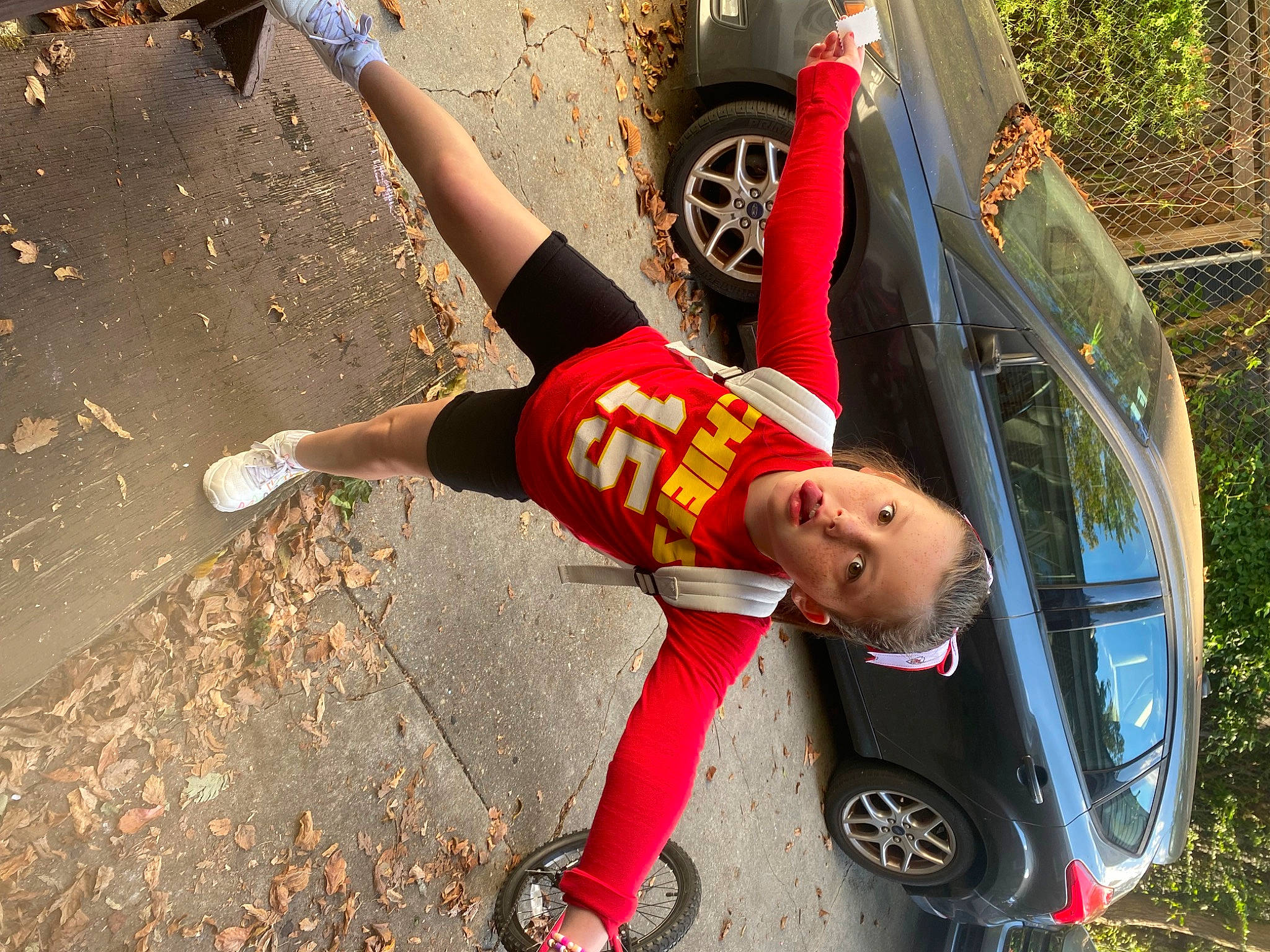Ava Yarnevich joined the competition — help win amazing prizes! asphalt, automotive_design, automotive_exterior, automotive_tire, automotive_wheel_system, bumper, car, human_leg, motor_vehicle, person, plant, rim, shorts, sneakers, thigh, tire, toddler, tree, vehicle, vehicle_door